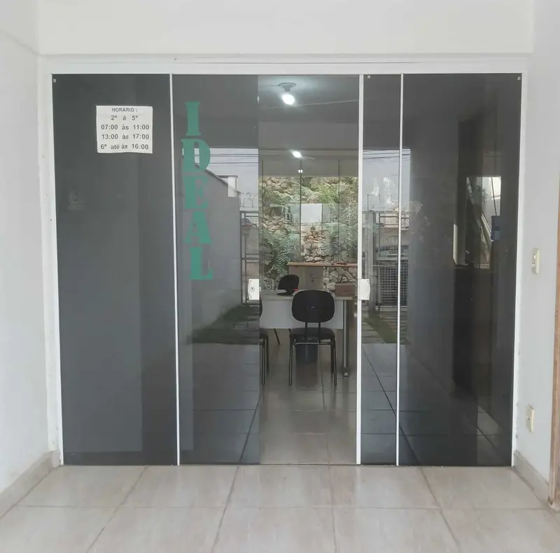 Entrada do laboratório Ideal: porta de vidro com o nome IDEAL em letras verdes e, ao fundo, a recepção.